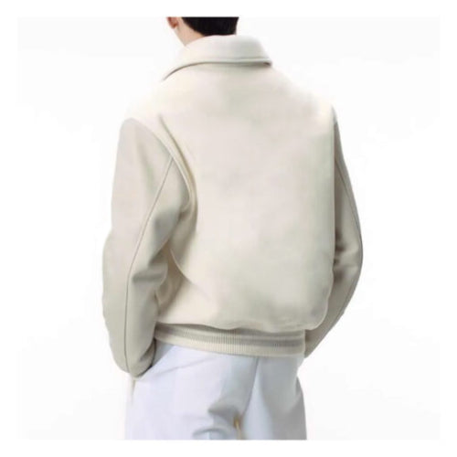 Man wearing a White Leather Varsity Jacket featuring sleek white leather sleeves, ribbed cuffs, and a classic varsity design that blends bold elegance with modern streetwear style.